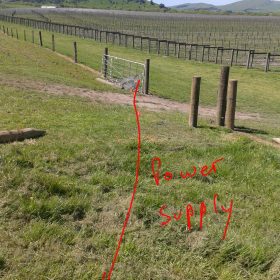Picture of farm paddock with red lines showing where electric cables are.